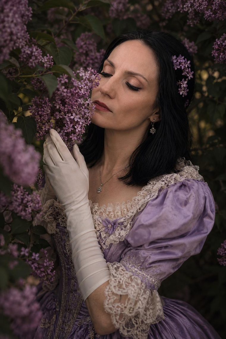 Portrait in period costume among lilac blossoms